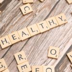 scrabble tiles spelling out the word healthy on a wooden surface